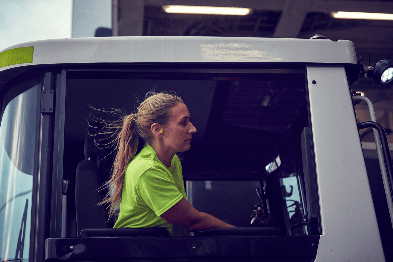 A woman driving a DFDS truck.