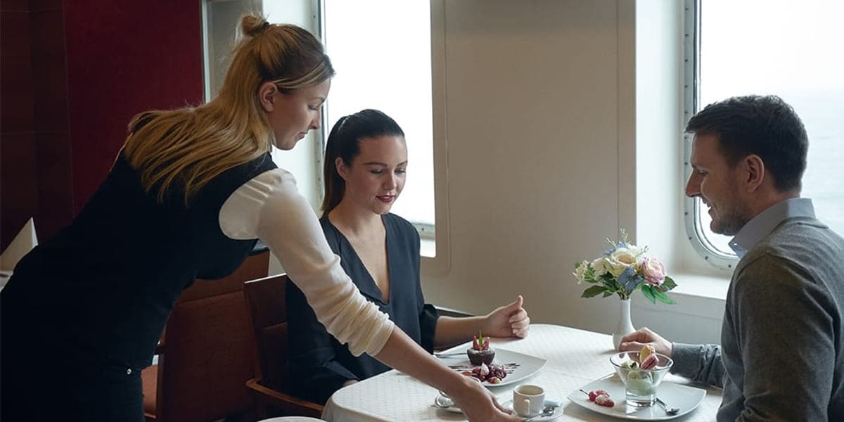 Kelnerka serwuje jedzenie parze w restauracji