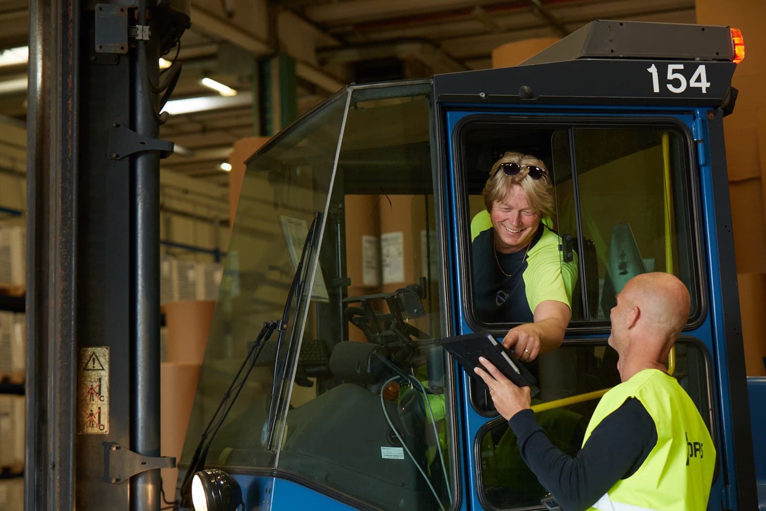 A woman driving a truck is helping her fellow DFDS colleague