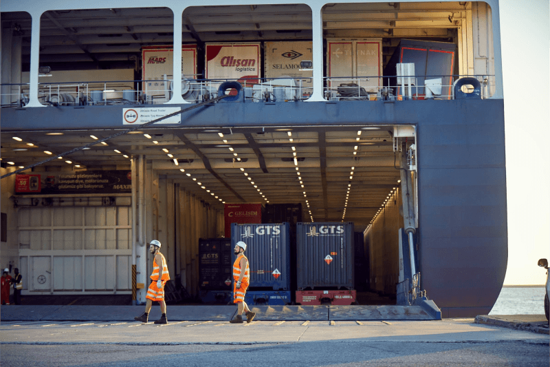 DFDS freight ship loading cargo , workers walking at terminal