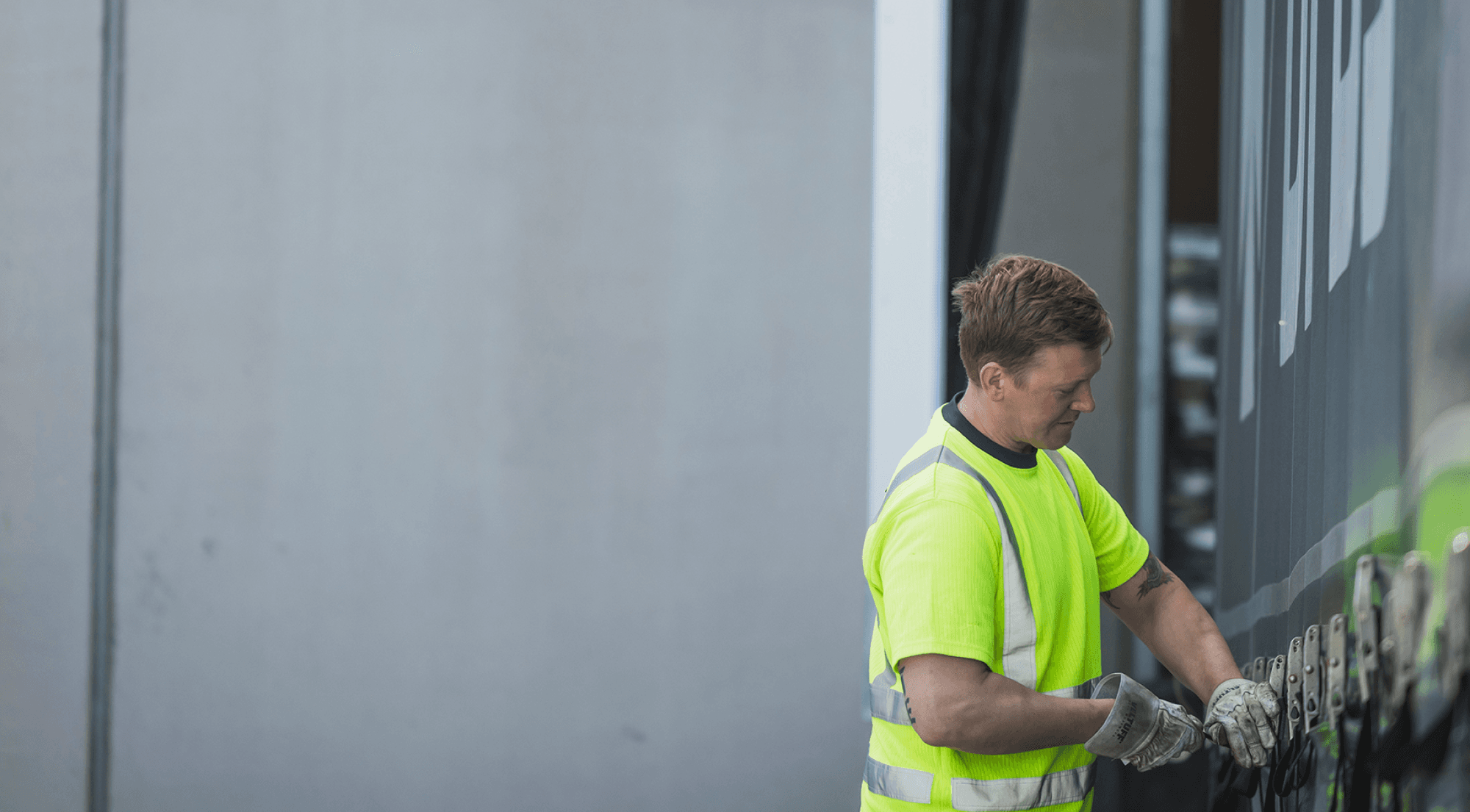 A DFDS driver wearing a high visibility vest prepares a truck for departure
