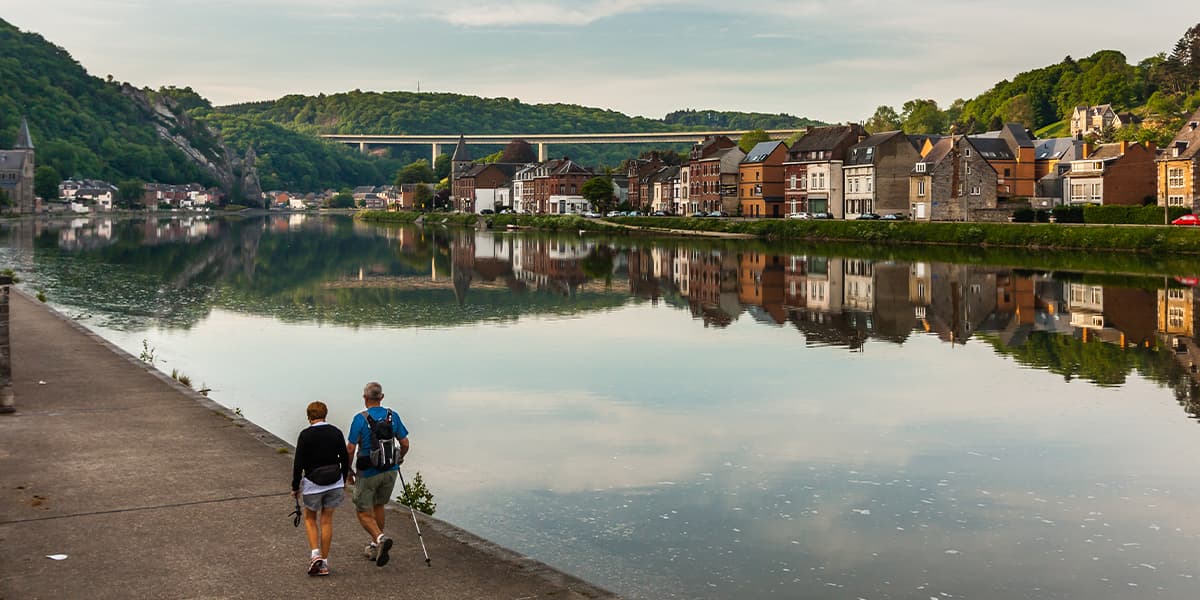 Couple walking along a river in Belgium