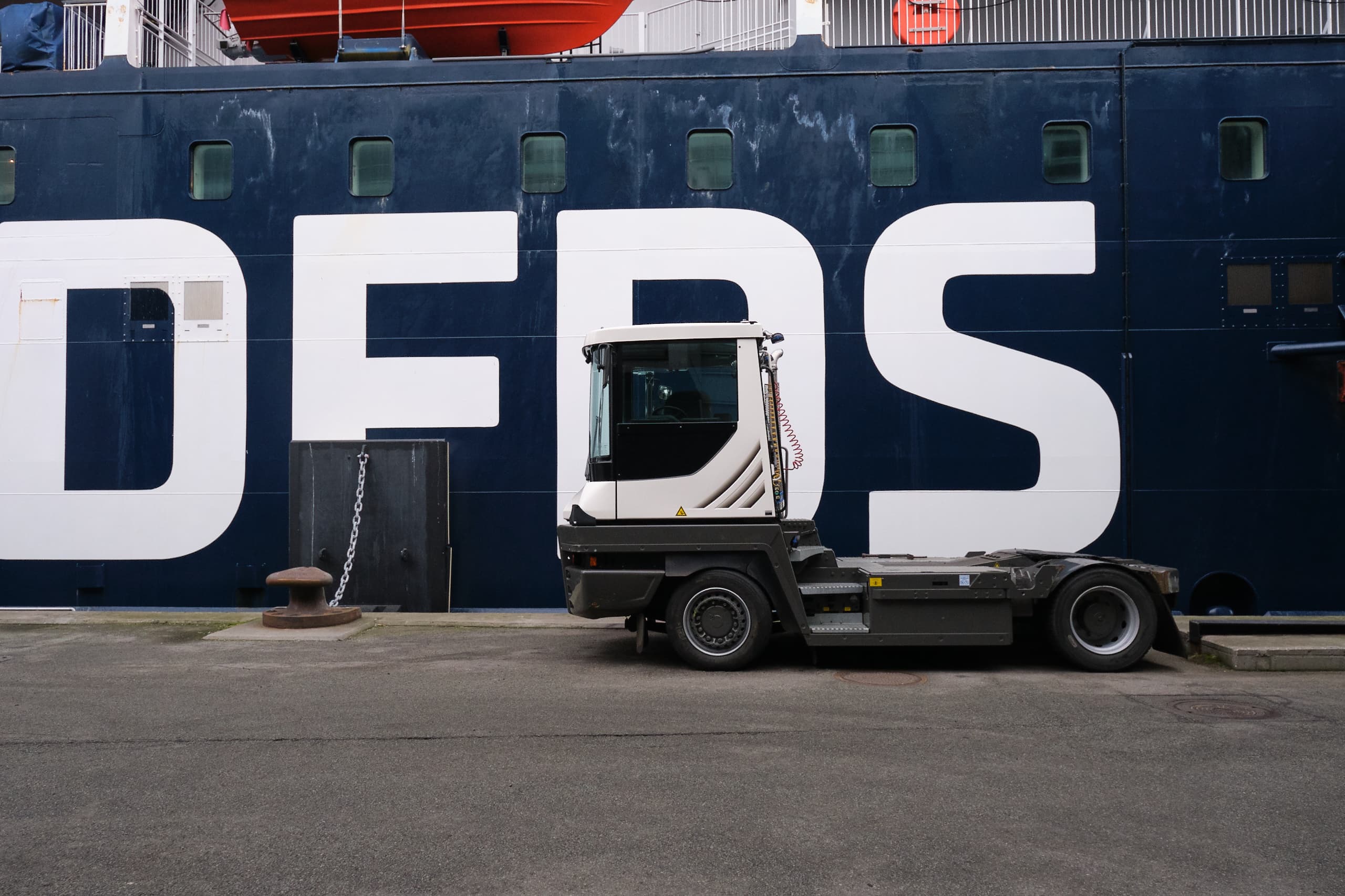 Photo of the side of DFDS ship with a tugmaster in front