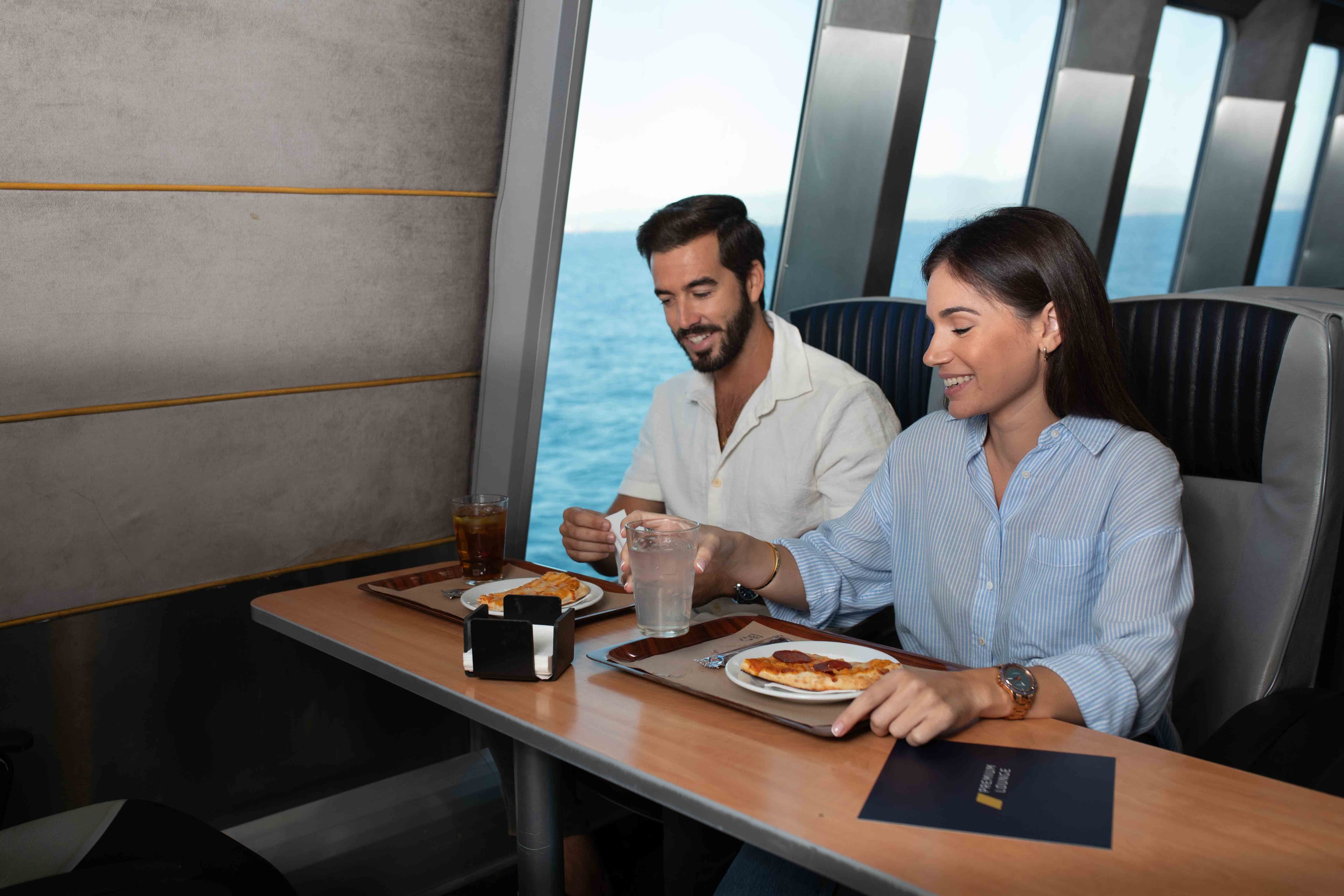 Un couple savoure un repas avec vue sur la mer dans un restaurant.
