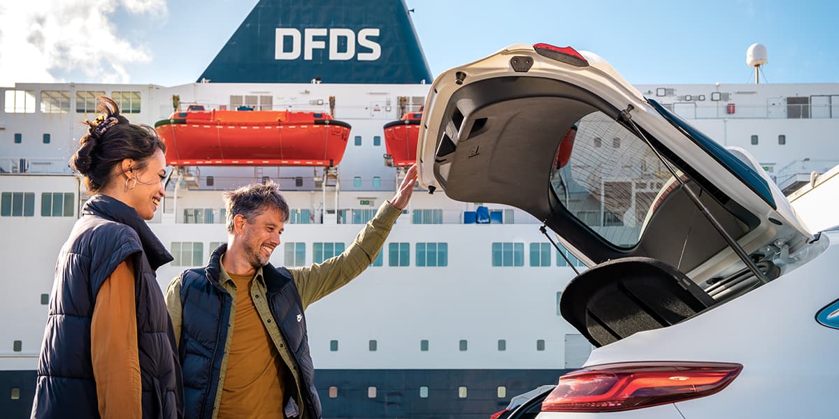 Couple looking in boot with DFDS ferry