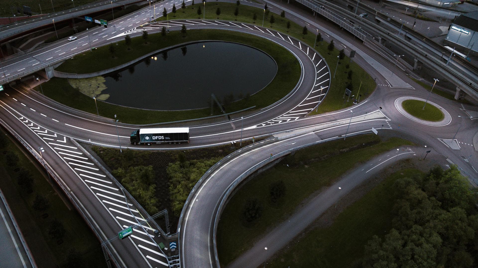 DFDS elektrinio sunkvežimio, vežančio prekes keliu, nuotrauka iš oro.